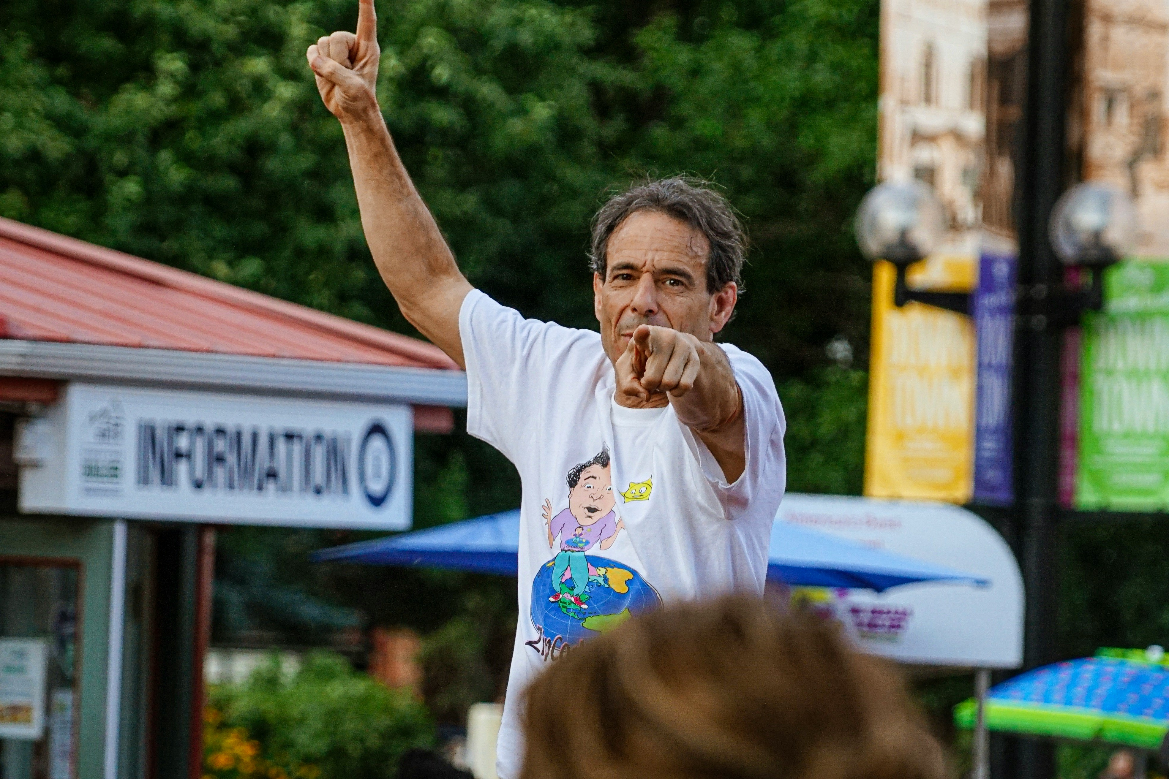 man in white crew neck t-shirt raising his right hand